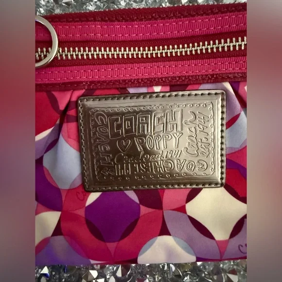 Coach Poppy Wristlet featuring a pink and purple geometric pattern. - Picture 4 of 9
